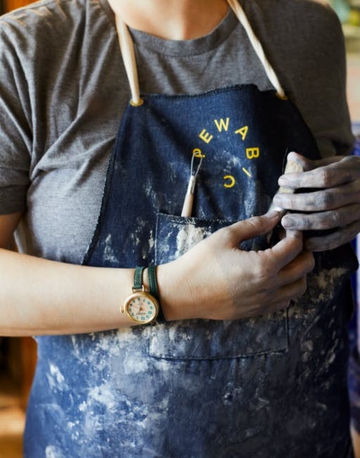 Artisan wearing an apron and a Shinola x Pewabic Runwell on their wrist