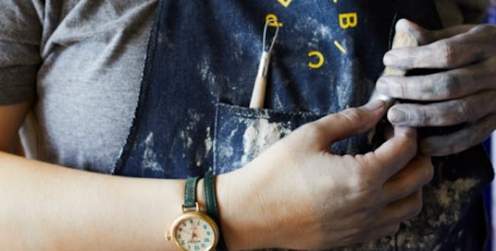 Artisan wearing an apron and a Shinola x Pewabic Runwell on their wrist