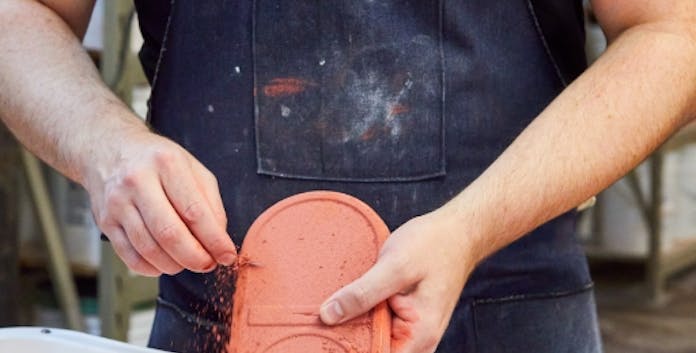 Artisan glazing a candle tray