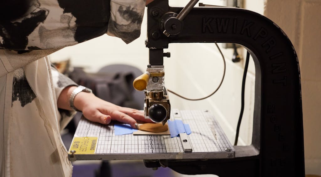 Darrin sewing a leather ornament at a sewing machine